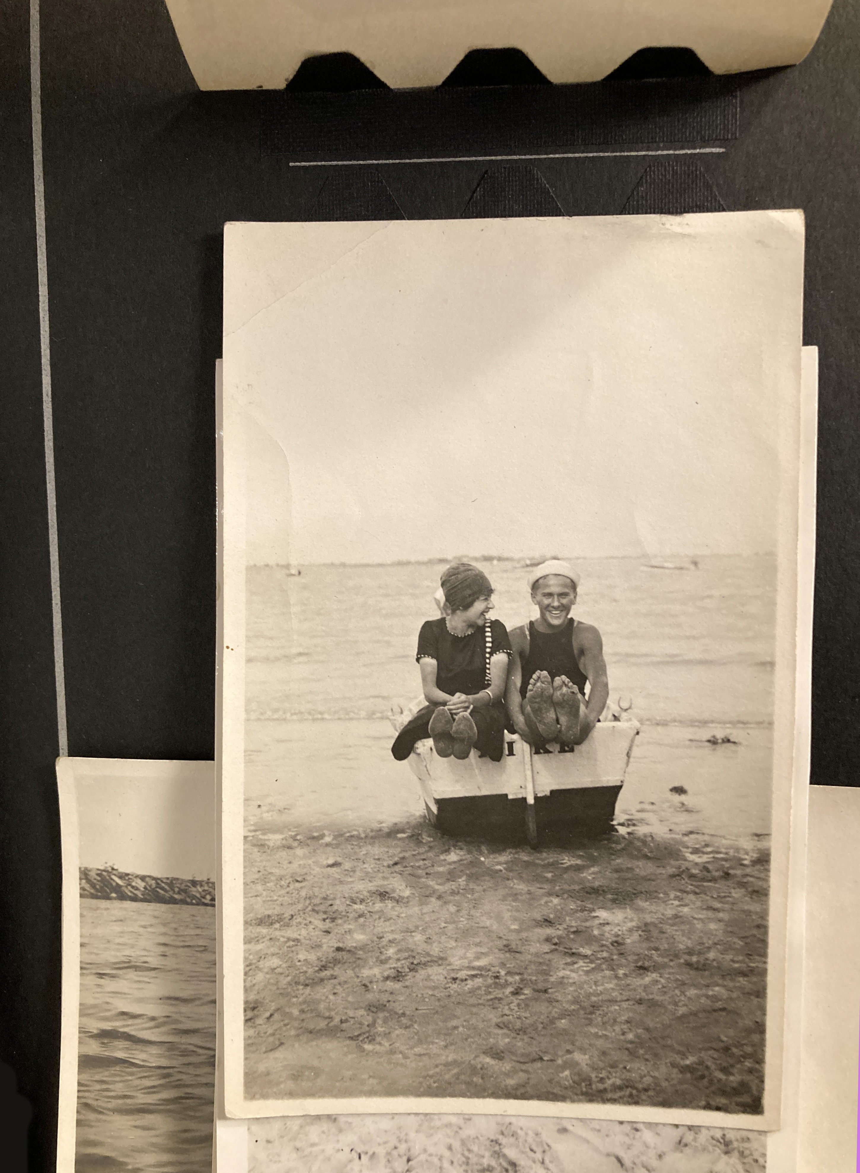 Man and woman sitting in a boat on the beach.