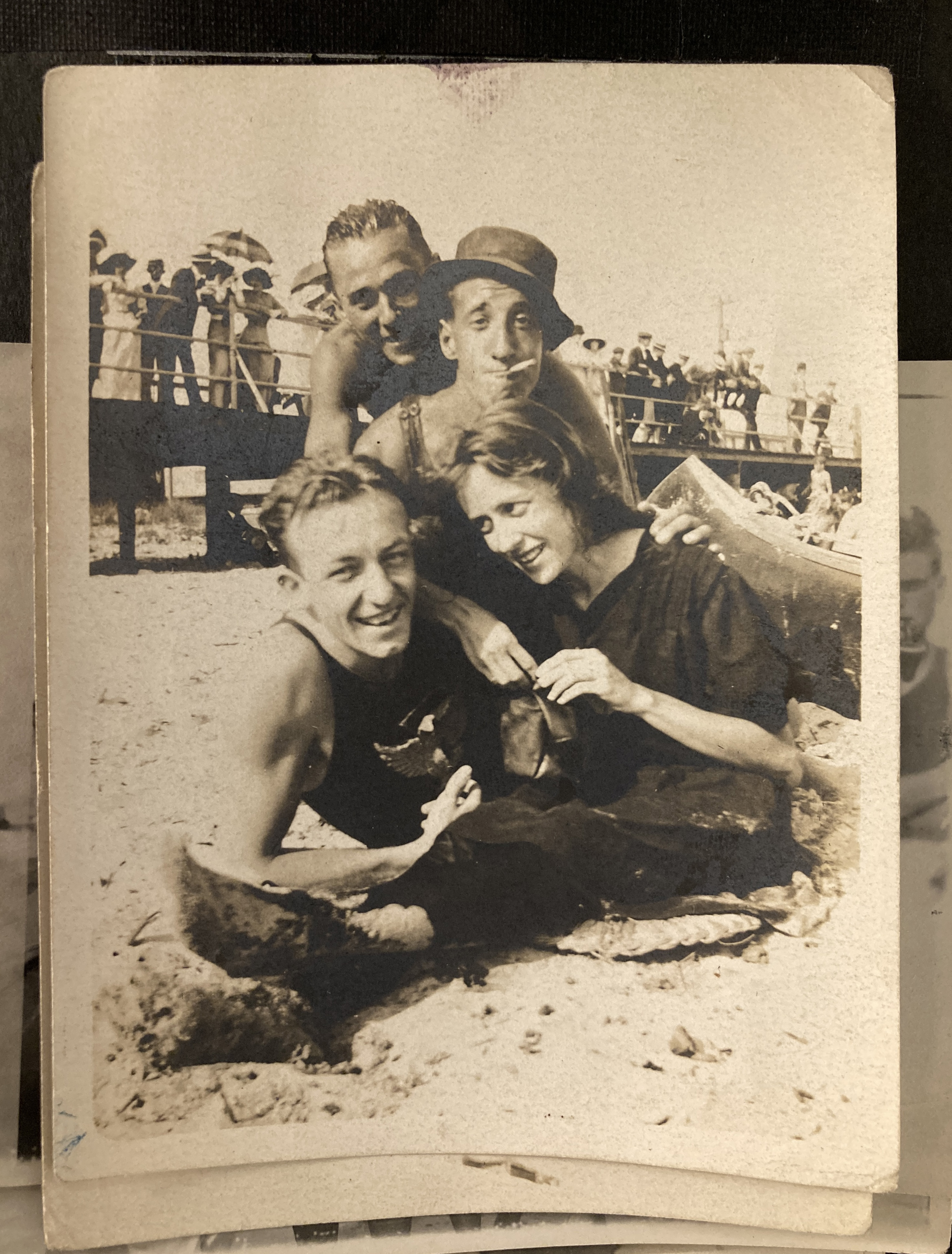 Four young adults sitting together on the beach.