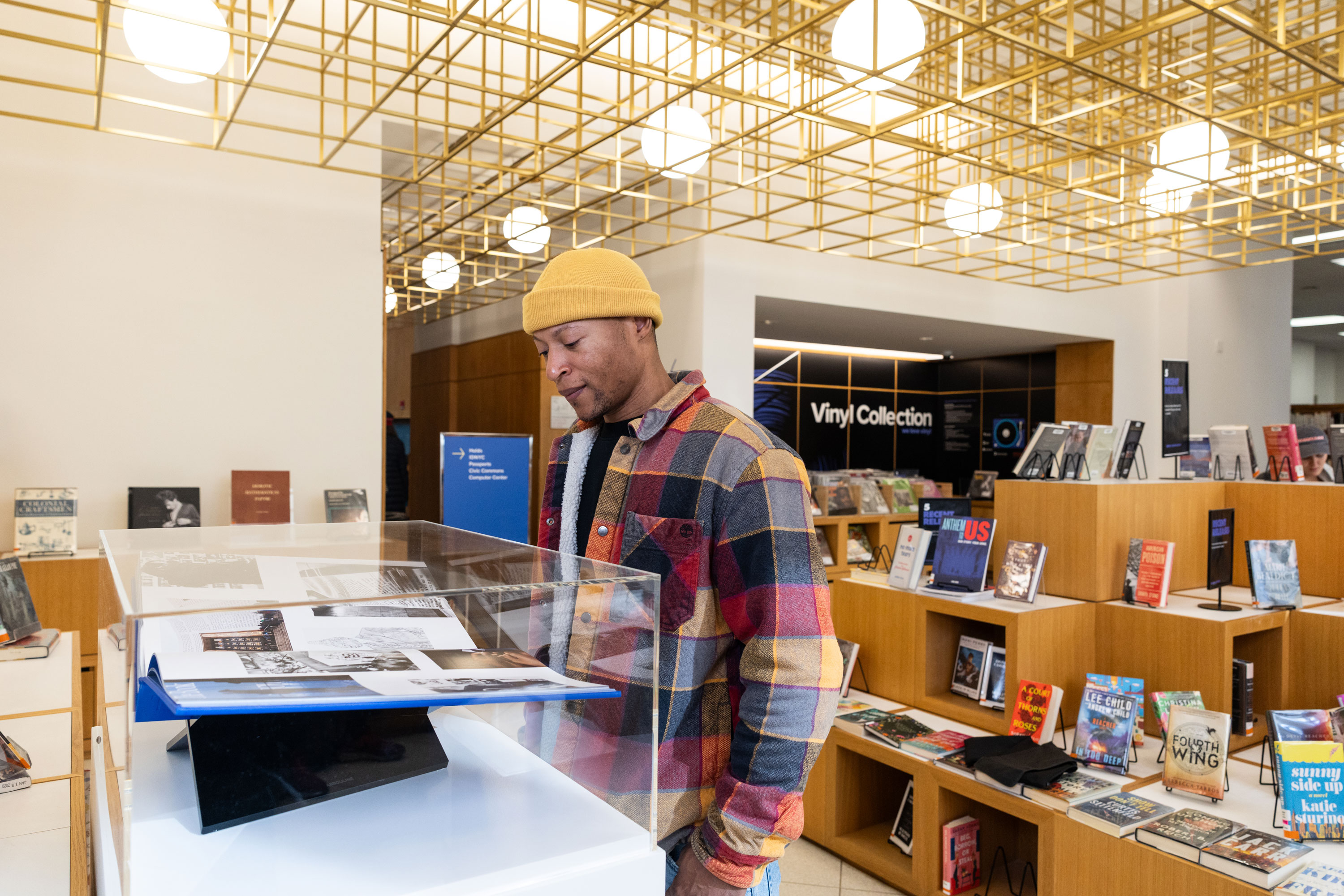 A man stands in the New and Noteworthy section, looking down at the book for the Book of HOV Exhibit