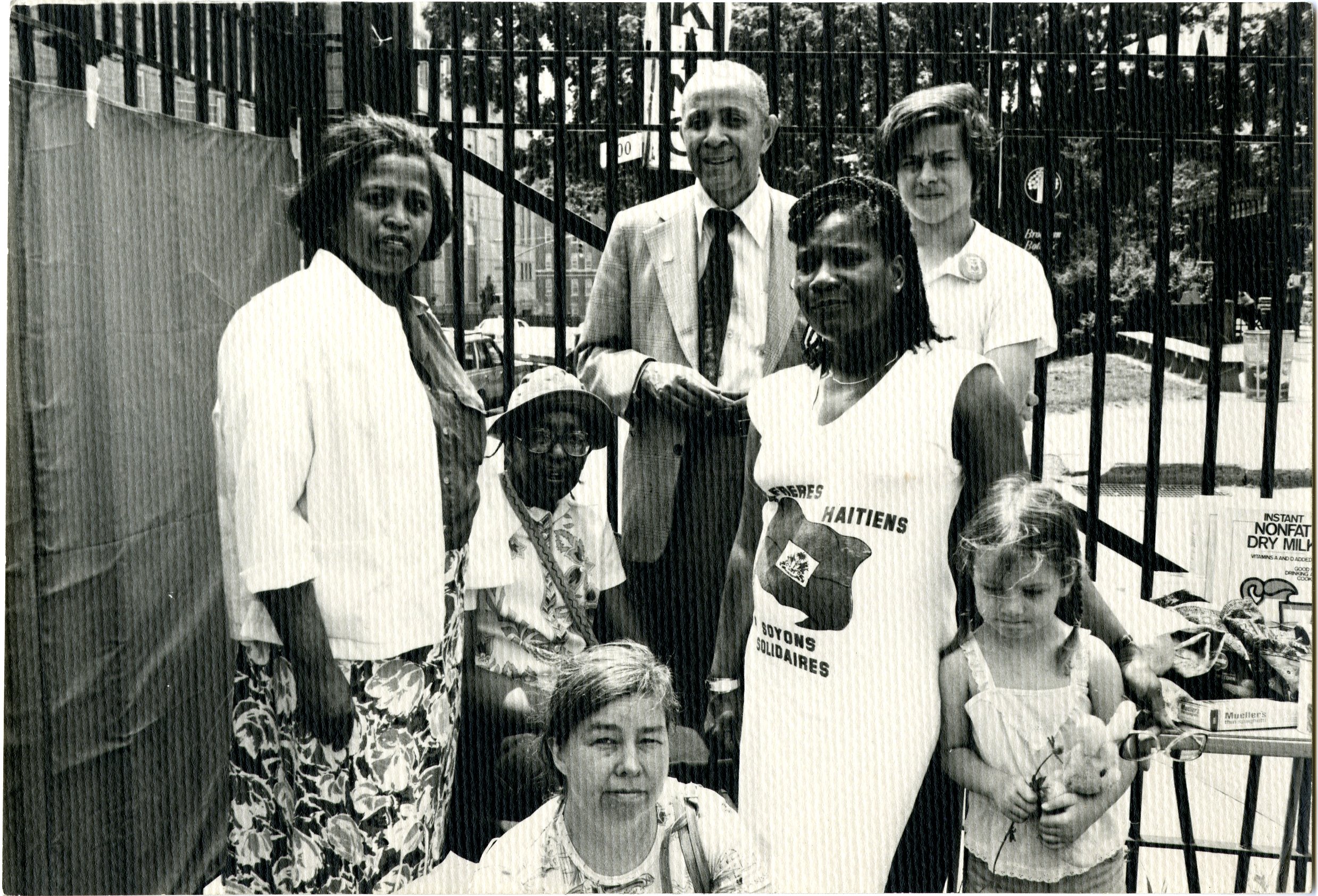 group of people in front of fence
