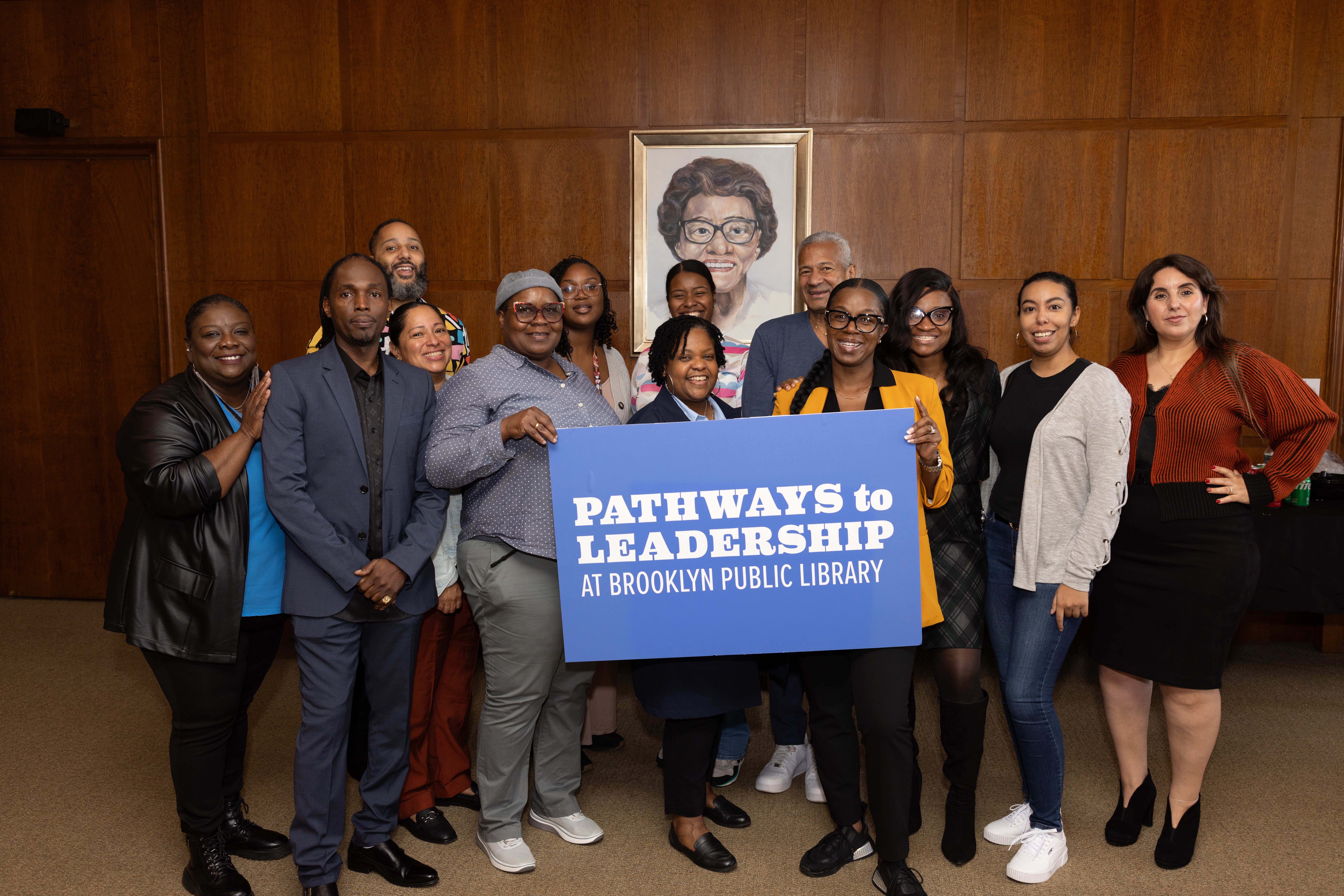 A diverse group of new Pathways to Leadership graduates pose together in BPL's Trustee's room