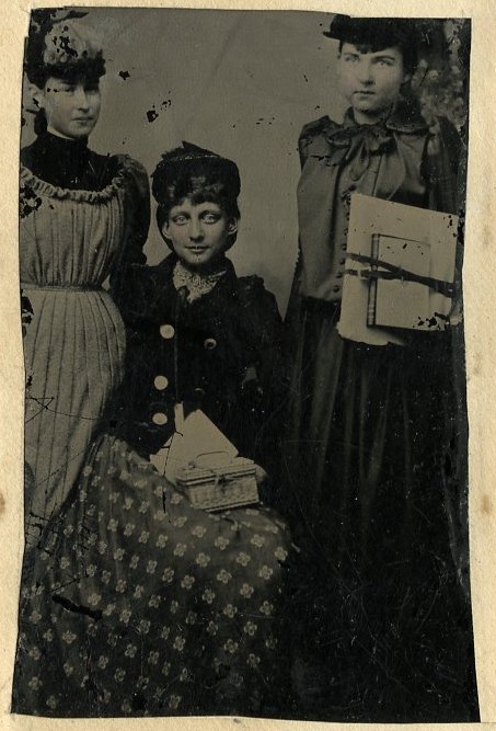 Black and white photograph of three young women in 19th century dress