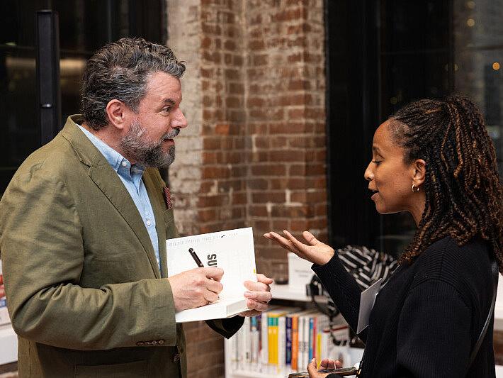 Charles Duhigg speaks with a woman as he signs her book