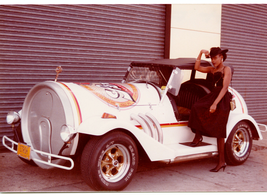 Person standing next to white car shaped like a beer can