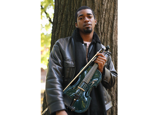 man in front of tree holding violin
