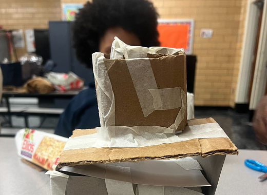 A child holds a project made in the Books and Building workshop. 