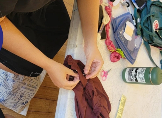 Repair cafe logo with image of a person sewing 