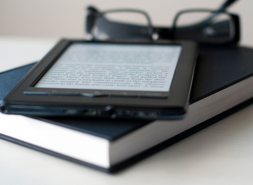 An ebook on top of a hardcover book