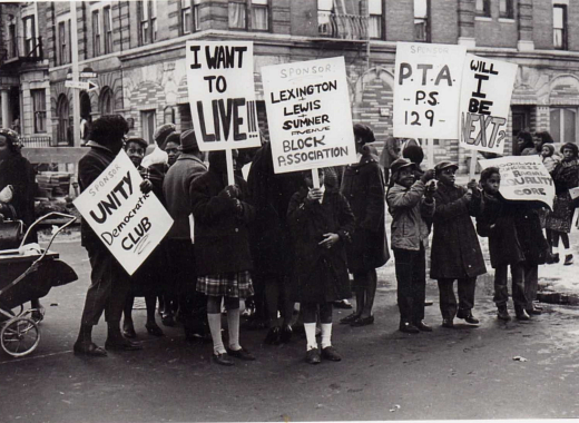 Brooklyn Congress of Racial Equality activists hold protest signs to advocate for traffic safety in Bed-Stuy