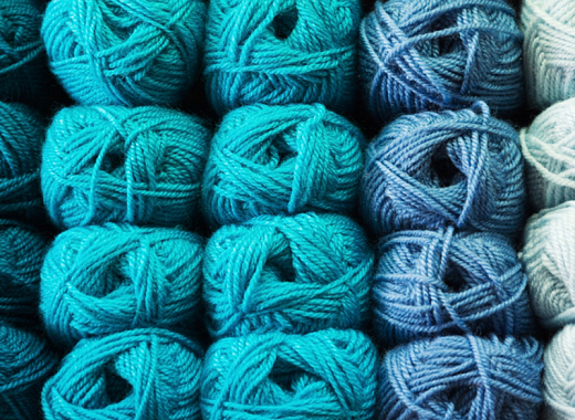 Skeins of blue wool are arranged in order from light to dark